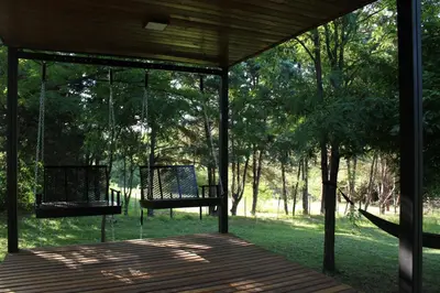 a porch with two swings in the trees at Rocio del Champaqui in Santa Rosa de Calamuchita