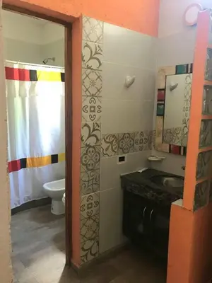 a bathroom with a sink and a toilet and a mirror at Rocio del Champaqui in Santa Rosa de Calamuchita