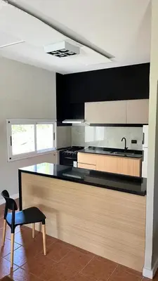 a kitchen with a counter with a sink and a chair at Rocio del Champaqui in Santa Rosa de Calamuchita