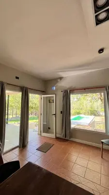 an empty living room with large windows and a door at Rocio del Champaqui in Santa Rosa de Calamuchita