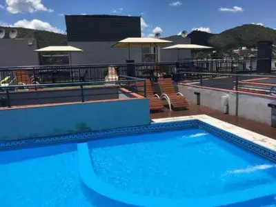 a large blue swimming pool on top of a building at Departamento Céntrico Miralejos 2 in Villa Carlos Paz