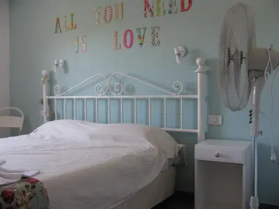 a bedroom with a white bed with a sign on the wall at Balcones de Los Chorrillos in Estancia Vieja