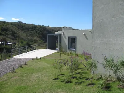 a house with a yard with plants in front of it at Balcones de Los Chorrillos in Estancia Vieja
