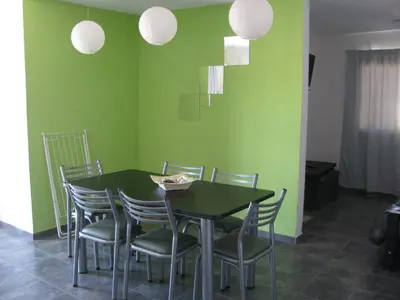 a dining room with green walls and a table and chairs at Balcones de Los Chorrillos in Estancia Vieja