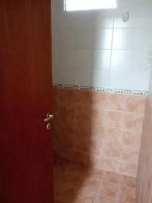 a bathroom with a shower with a brown door at Nélida Dpto 4 in Villa Carlos Paz