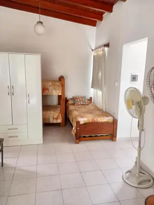 a bedroom with a bed and a desk and a fan at Nélida Dpto 4 in Villa Carlos Paz