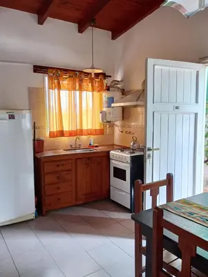 a kitchen with a white refrigerator and a sink at Nélida Dpto 4 in Villa Carlos Paz