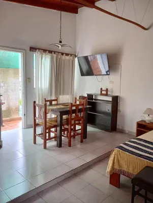 a dining room with a table and chairs and a television at Nélida Dpto 4 in Villa Carlos Paz