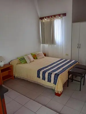 a bedroom with a bed and a chair in it at Nélida Dpto 4 in Villa Carlos Paz