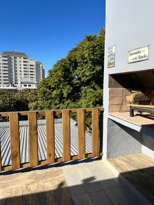 a balcony with a wooden fence next to a building at Único y hermoso in Cordoba