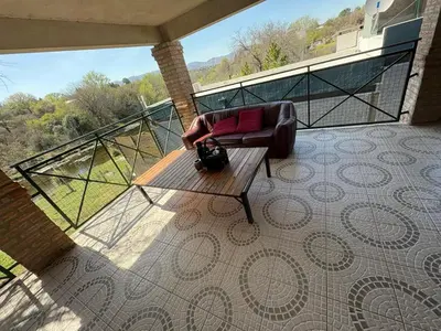 a balcony with a chair and a bench on a patio at CASA EL GRINGO ubicada en Villa Parque Siquiman con vista al río tres habitaciones y capacidad para ocho personas in Villa Parque Siquiman