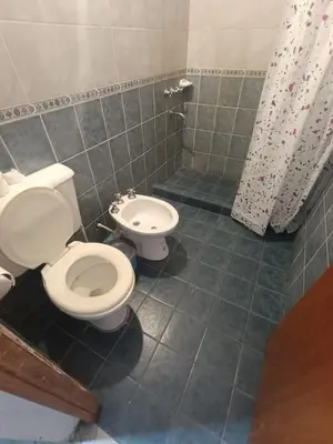a bathroom with a white toilet and a shower at CASA EL GRINGO ubicada en Villa Parque Siquiman con vista al río tres habitaciones y capacidad para ocho personas in Villa Parque Siquiman