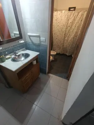 a bathroom with a sink and a mirror and a toilet at CASA EL GRINGO ubicada en Villa Parque Siquiman con vista al río tres habitaciones y capacidad para ocho personas in Villa Parque Siquiman
