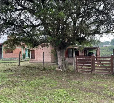 a tree in front of a fence in front of a house at CASA EL GRINGO ubicada en Villa Parque Siquiman con vista al río tres habitaciones y capacidad para ocho personas in Villa Parque Siquiman