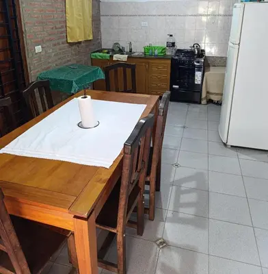 a kitchen with a wooden table and a refrigerator at CASA EL GRINGO ubicada en Villa Parque Siquiman con vista al río tres habitaciones y capacidad para ocho personas in Villa Parque Siquiman