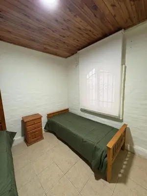 a bedroom with a green bed and a window at Casa La Tranquilidad in La Porteña