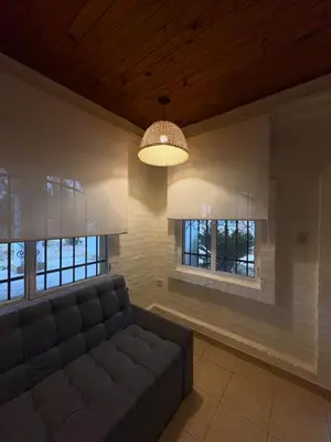 a living room with a couch and two windows at Casa La Tranquilidad in La Porteña
