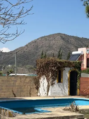 a house with a swimming pool in front of a mountain at Casa La Tranquilidad in La Porteña