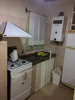 a kitchen with a white stove and a white refrigerator at Casa La Tranquilidad in La Porteña