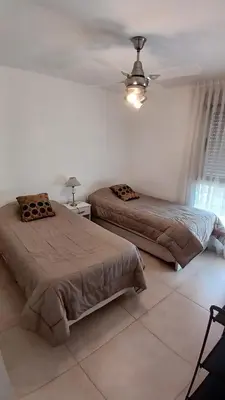 a bedroom with two beds and a ceiling fan at Cordoba temporario in Cordoba
