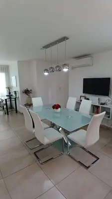a dining room with a glass table and white chairs at Cordoba temporario in Cordoba