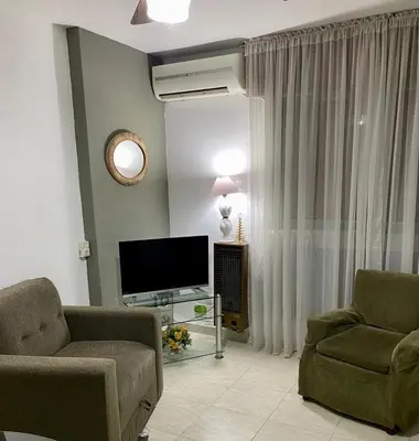 a living room with two chairs and a television at Departamento en calle Ayacucho in Cordoba