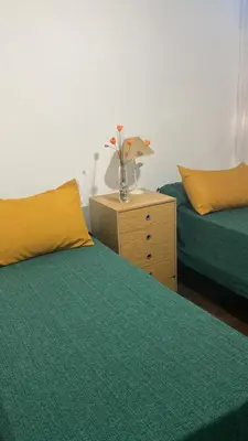 a bedroom with two beds and a table with a vase at Departamento en calle Ayacucho in Cordoba