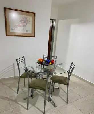 a glass table with chairs and a bowl of fruit on it at Departamento en calle Ayacucho in Cordoba