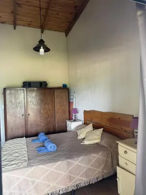 a bedroom with a large bed with blue towels on it at Cabaña Zara in Villa Yacanto
