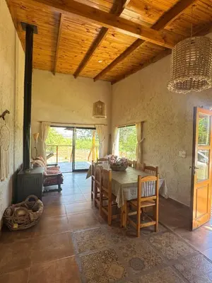 a dining room with a table and chairs at Cabaña Zara in Villa Yacanto