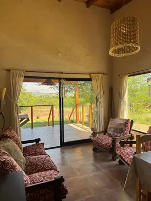 a living room with couches and a sliding glass door at Cabaña Zara in Villa Yacanto