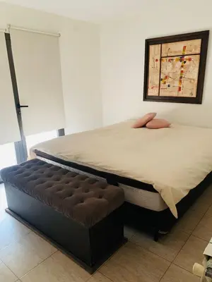 a bedroom with two beds and a ottoman at La Estanzuela FM in La Calera