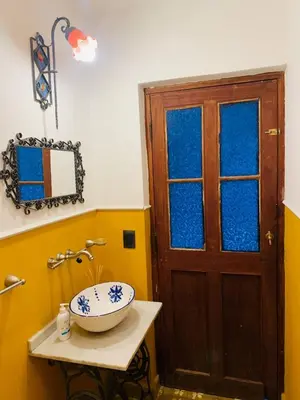 a bathroom with a sink and a wooden door at La Estanzuela FM in La Calera