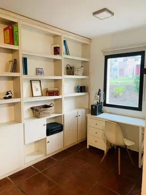 a room with a window and a desk and bookshelves at La Estanzuela FM in La Calera