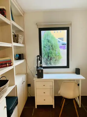 a desk with a window and a chair in a room at La Estanzuela FM in La Calera