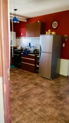 a kitchen with red walls and a stainless steel refrigerator at Casa Tanti in Tanti
