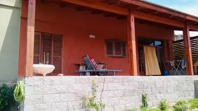 a red house with a table in front of it at Casa Tanti in Tanti