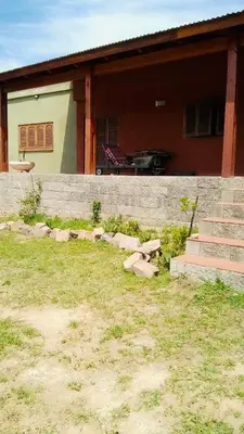 a house with a stone wall and a yard at Casa Tanti in Tanti