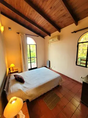 a bedroom with a large bed and a large window at Cabañas El Paso in Villa del Dique