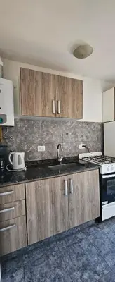 a kitchen with wooden cabinets and a sink and a stove at Dpto temporario Cba in Cordoba