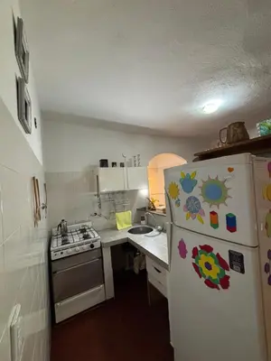 a small kitchen with a refrigerator and a stove at Casa con vista y acceso al río in Villa Icho Cruz