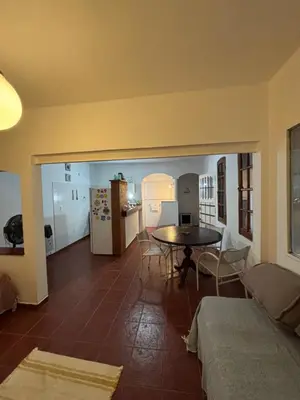 a living room with a table and a kitchen at Casa con vista y acceso al río in Villa Icho Cruz