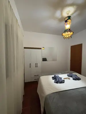 a bedroom with a bed and a chandelier at Casa con vista y acceso al río in Villa Icho Cruz