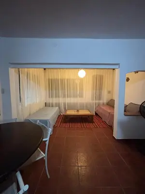 a room with two beds and a table in it at Casa con vista y acceso al río in Villa Icho Cruz