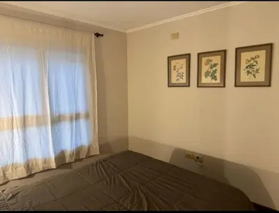 a bedroom with a bed and a window with two pictures at Departamento un dormitorio Frente al Pocito in Cordoba
