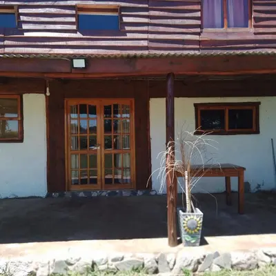a house with a table in front of it at Cabaña Mitimay in Alta Gracia