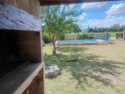 a dog laying on the grass next to a building at Cabaña Mitimay in Alta Gracia