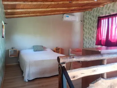 a bedroom with a bed and a red window at Cabaña Mitimay in Alta Gracia