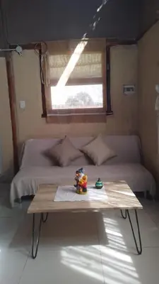 a room with a bed and a table in front of it at Cabaña Mitimay in Alta Gracia