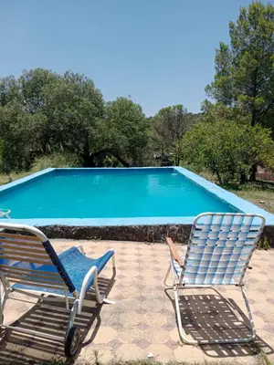 two chairs sitting next to a swimming pool at La Pasionaria, casa de campo con pileta in Villa García